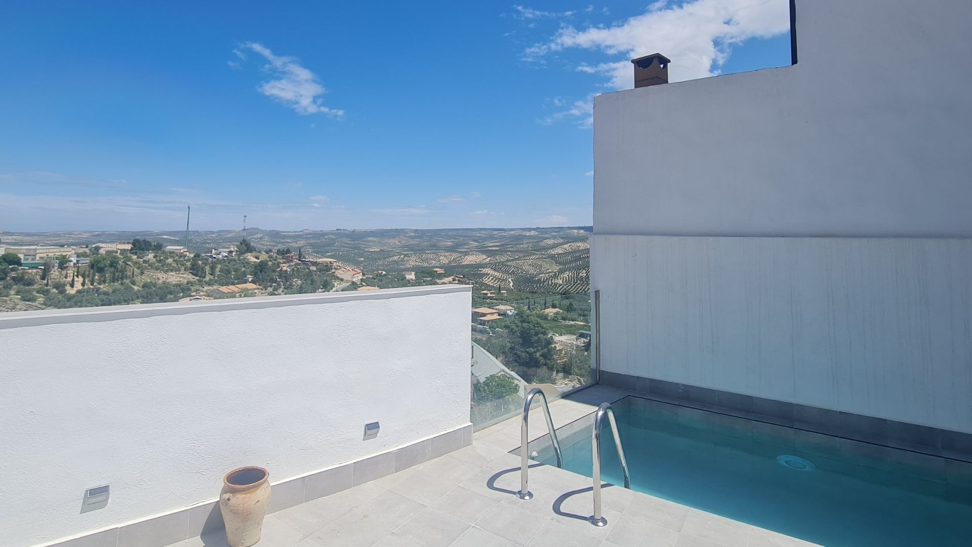 Espacio exterior con pequeña piscina y vistas abiertas a un paisaje de olivares y colinas. Un lugar pensado para relajarse, disfrutar del aire libre y contemplar el entorno.