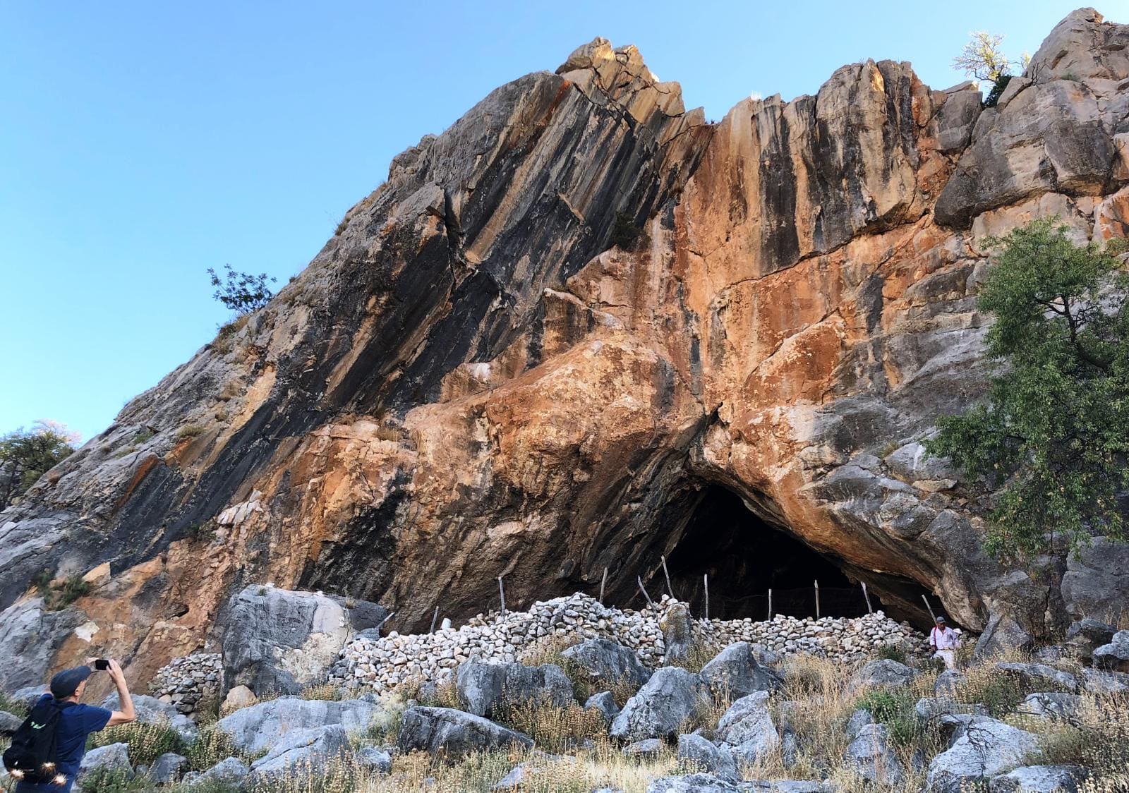 en la imagen se ve una montaña de piedra y debajo una cueva