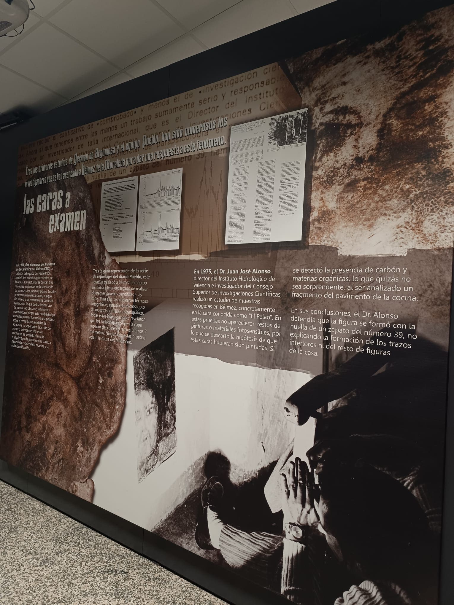 Panel expositivo interior sobre las investigaciones científicas de las Caras de Bélmez, con textos explicativos, documentos reproducidos y una gran imagen en tonos oscuros relacionada con el fenómeno.