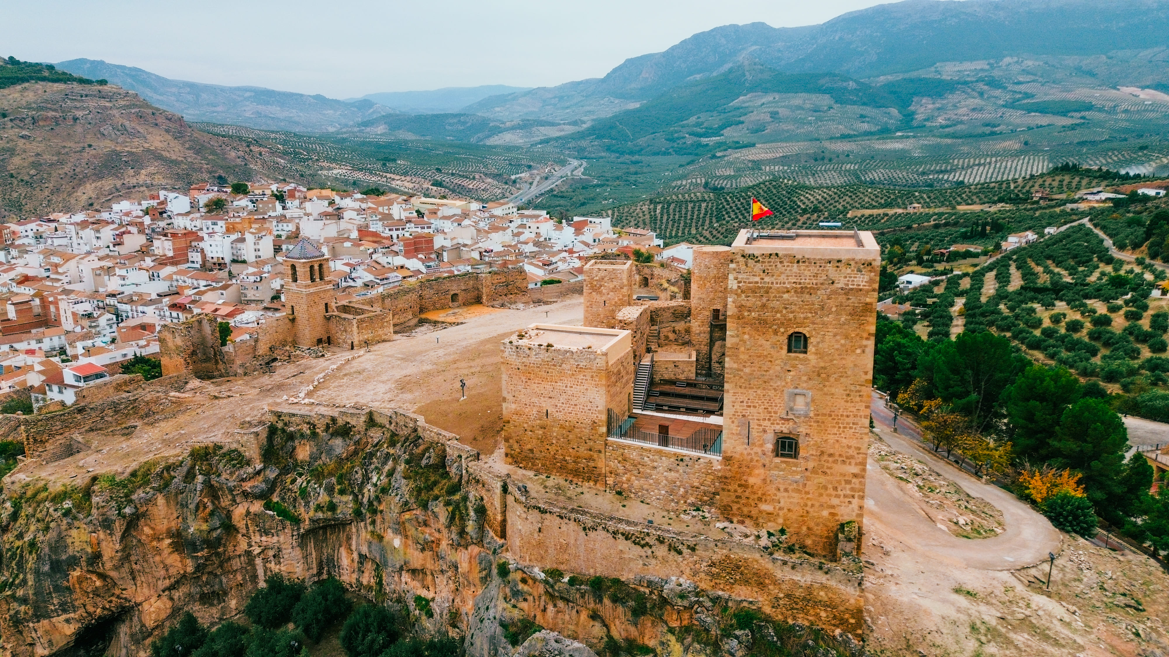 vista aérea del castillo de la guardia de jaén y al fondo montañas y olivos
