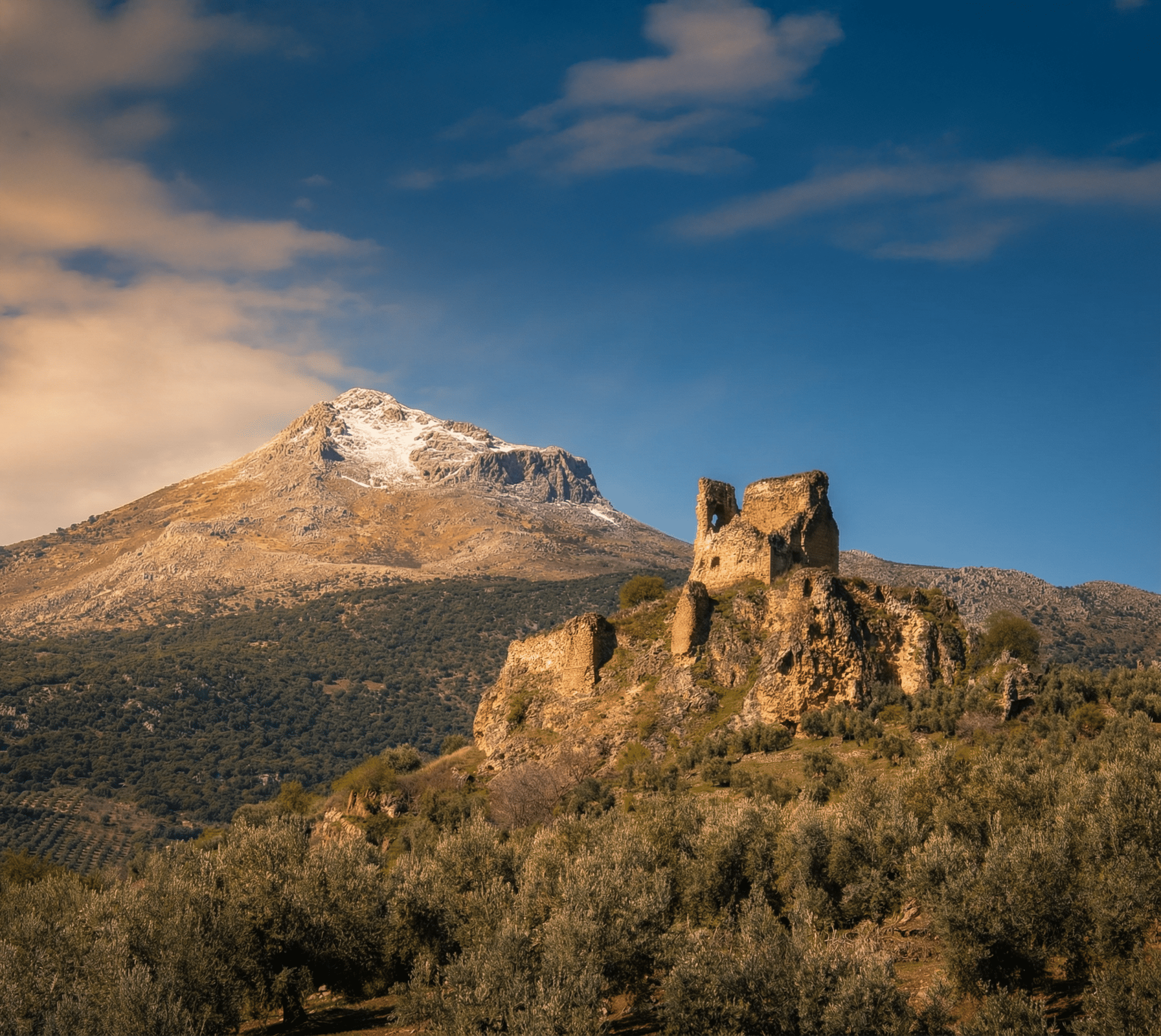 en la imagen se ve los restos de una fortaleza y al fondo la Sierra Bélmez