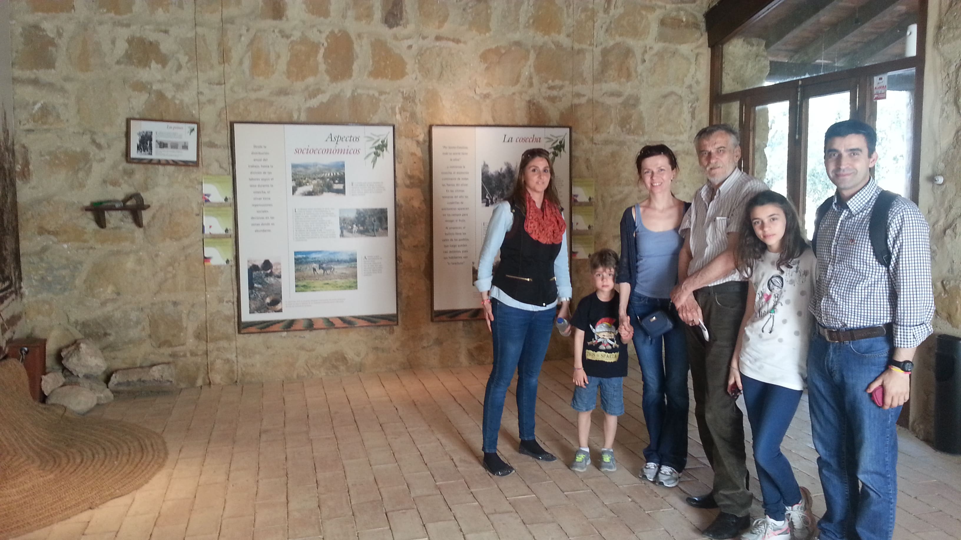 Grupo de personas en el interior de un espacio expositivo relacionado con la cultura del aceite de oliva.