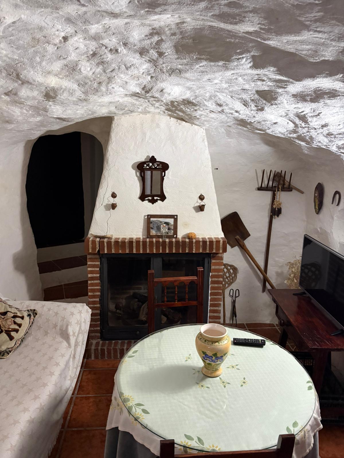 Zona de estar con chimenea integrada, donde destacan los elementos tradicionales y el mobiliario de madera. Un espacio acogedor pensado para reunirse y descansar.