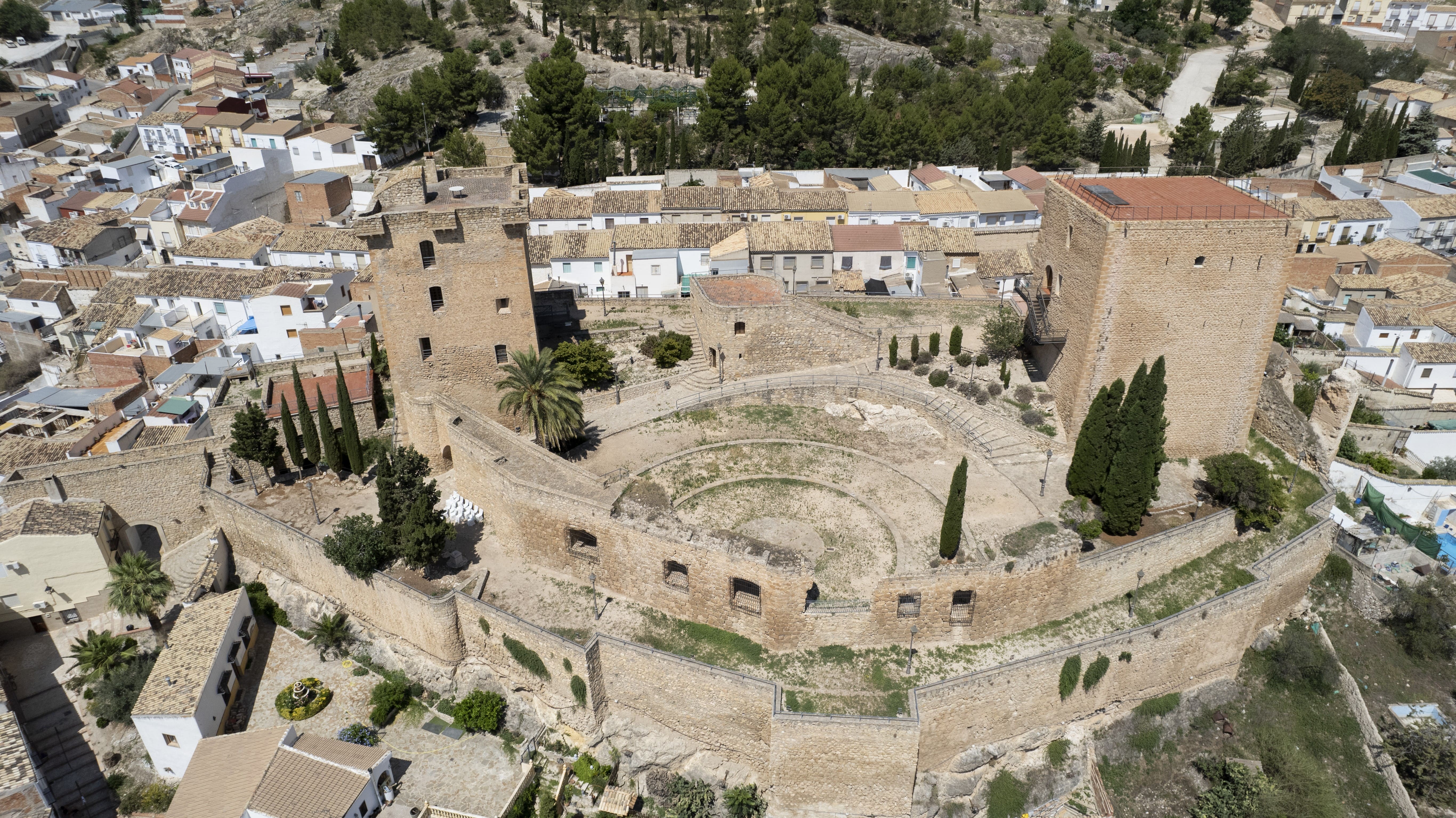 Vista aérea del Castillo de Jódar, con sus torres, murallas y patio interior, situado sobre un promontorio junto a las casas del municipio.