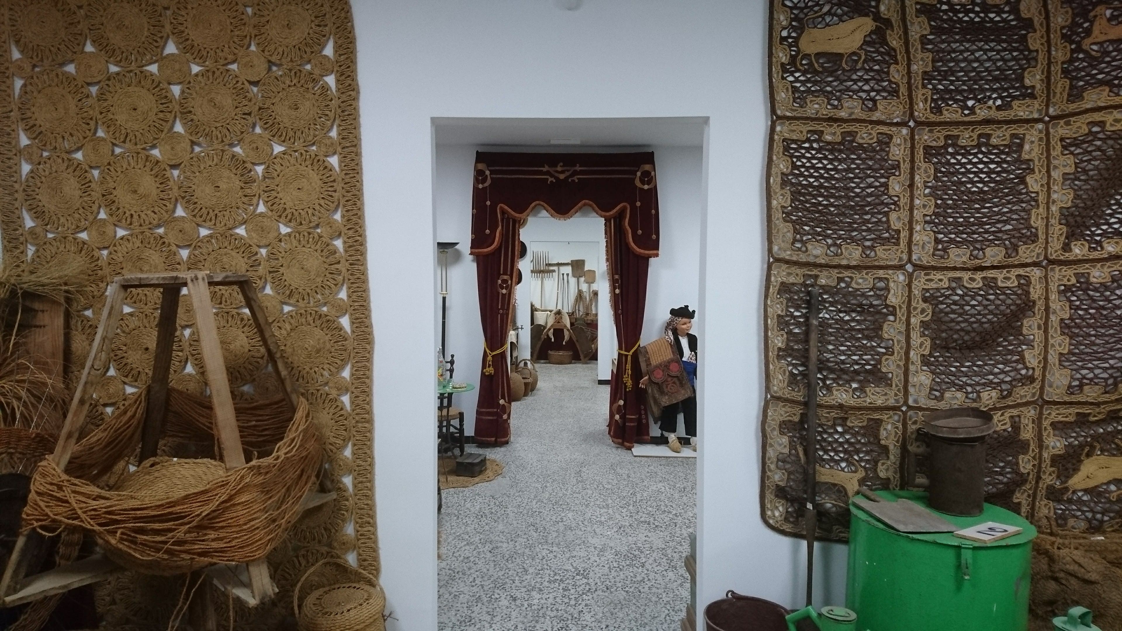 Sala expositiva interior con objetos tradicionales de esparto y utensilios antiguos, dispuestos como parte del recorrido museográfico del centro de interpretación.