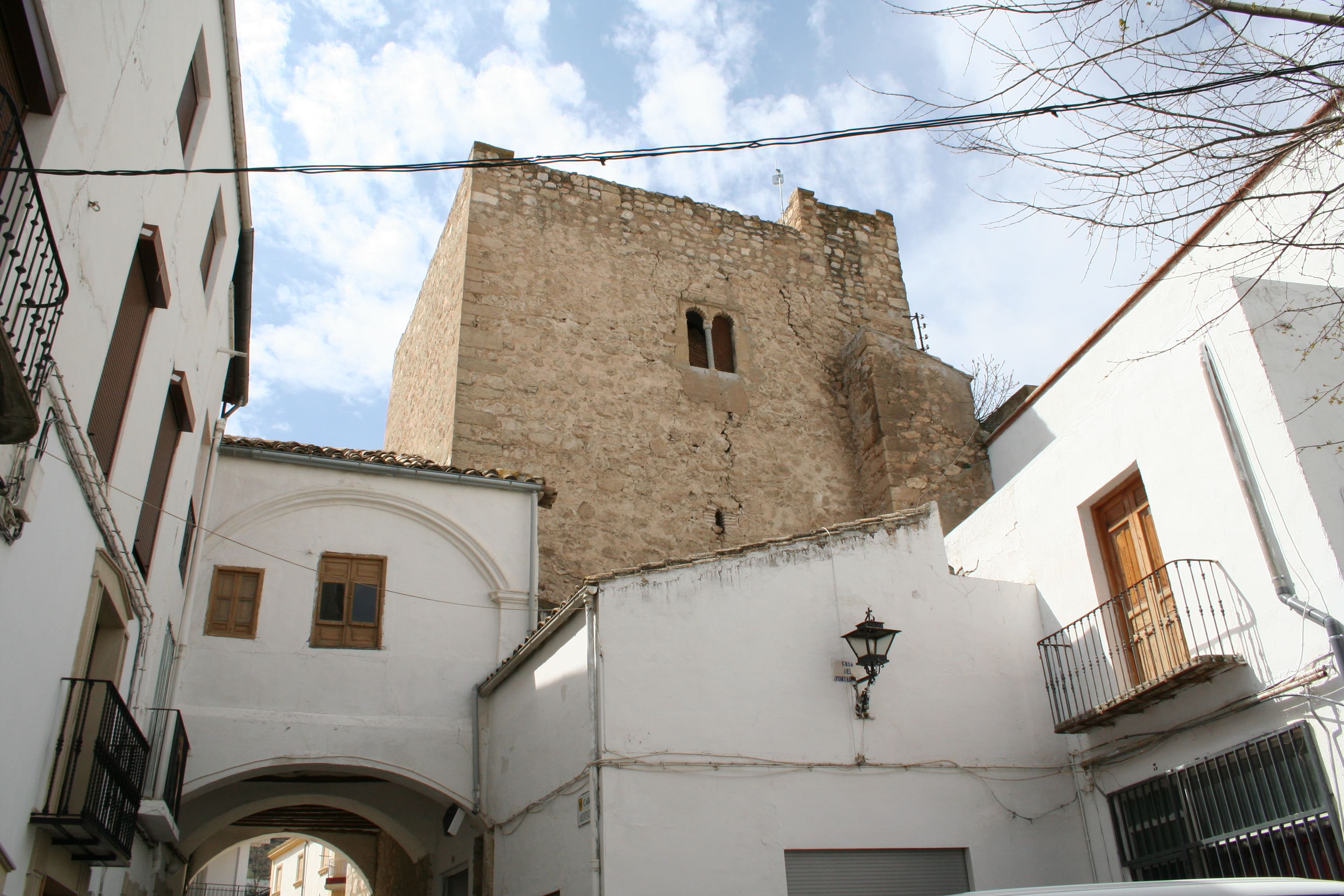 en la imagen se puede ver una casas de pueblo desde donde se puede contemplar una torre del castillo
