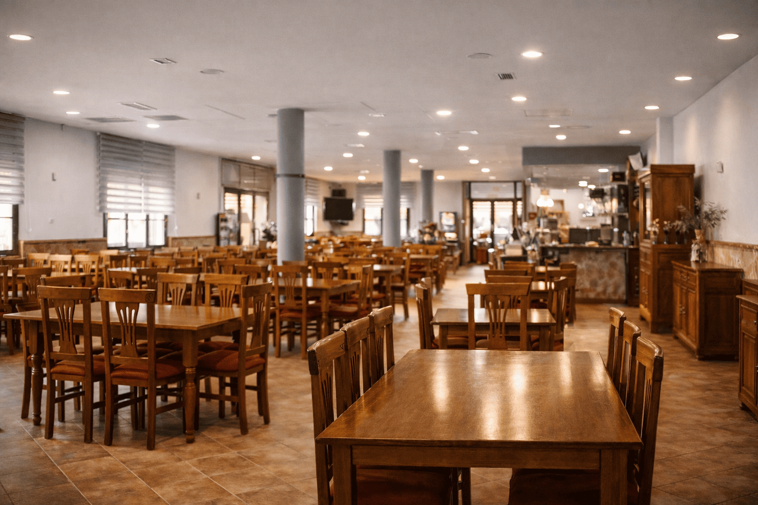 El comedor del restaurante, con varias mesas de madera dispuestas en el espacio. El ambiente es amplio y luminoso, con un estilo rústico.