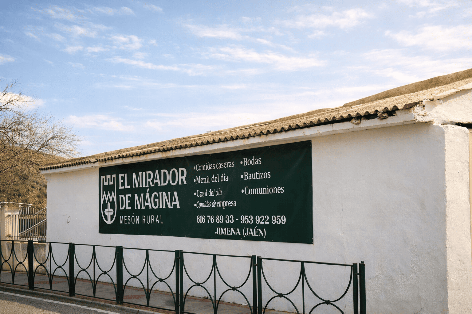 El cartel que da la bienvenida al restaurante El Mirador de Mágina, mostrando su oferta de comidas caseras, menú del día, y otros servicios como bodas, bautizos y comuniones.