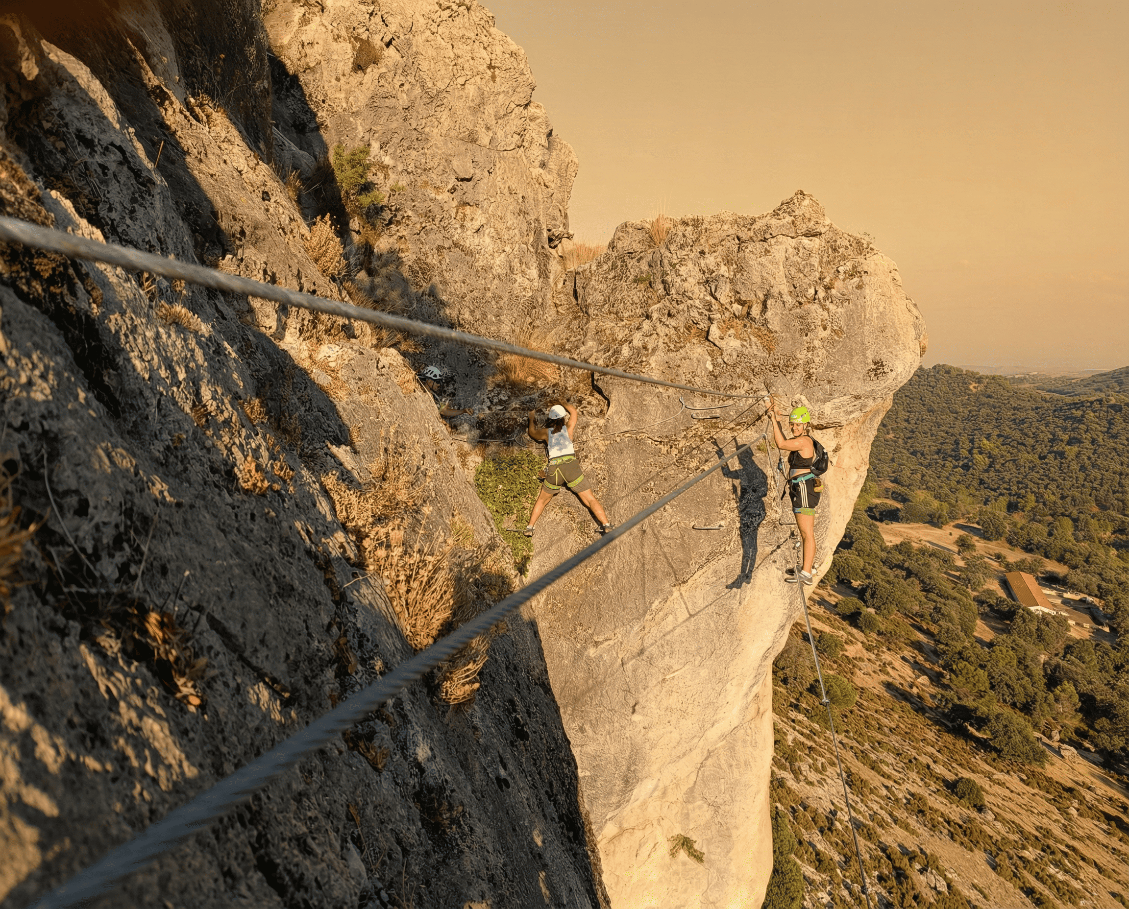 personas haciendo escalada en la pared de una montaña