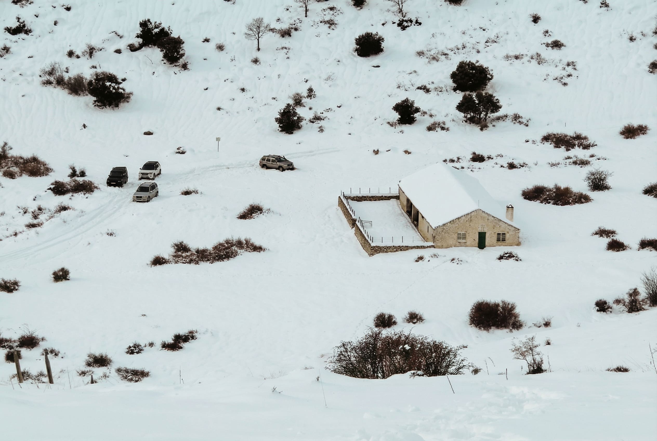 en la imagen se ve una zona de montaña nevada y en mitad una casa