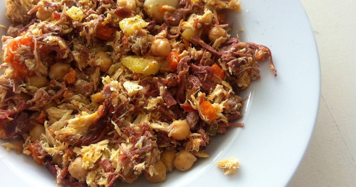Ropa vieja servida en un plato blanco, elaborada con carne desmenuzada, garbanzos y verduras del cocido. Presenta una textura seca y jugosa a la vez, con trozos dorados y aspecto casero, propio de una receta tradicional de aprovechamiento.