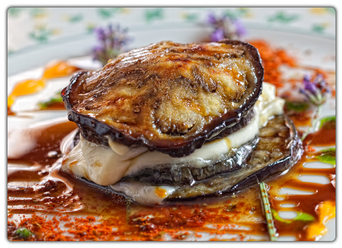 La berenjena está presente en muchos platos, como parte de pistos, o en distintos guisos y frituras, acompañando a la carne de monte, dadas sus cualidades como favorecedor de la digestión de carnes y grasas.  En esta ocasión se nos ofrece una posibilidad diferente de mezclar el sabor de las berenjenas de temporada con el queso del país.