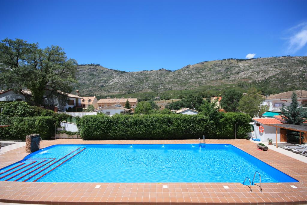 Amplia piscina de verano con zonas para descansar y tomar el sol.